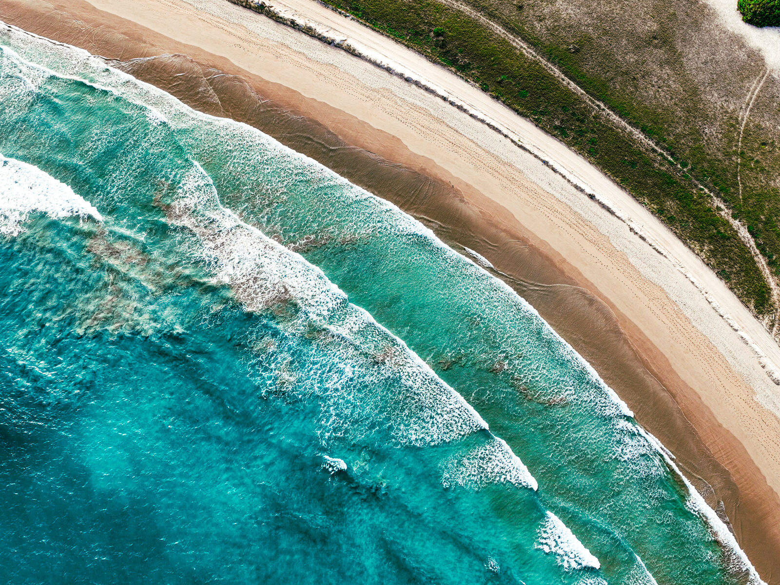 Waves rolling onto an Isabela beach from above